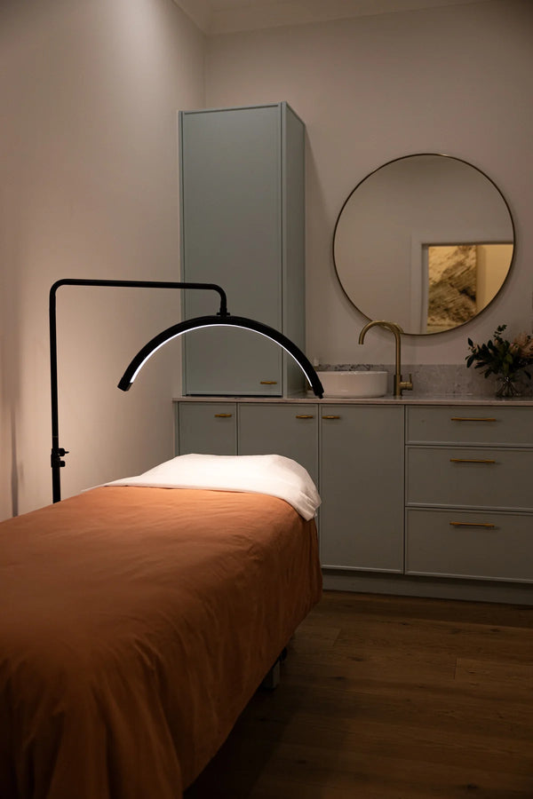 Bedroom with a bed, lamp, and vanity area.