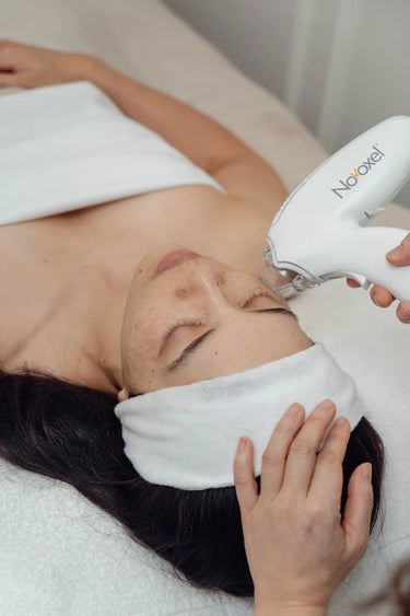 Person receiving a facial treatment with a Tixel device.