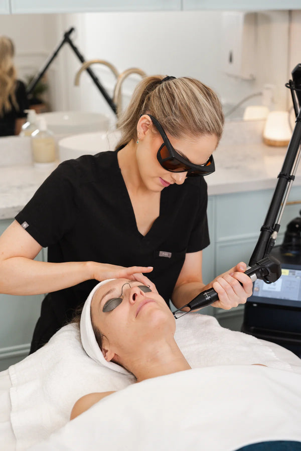 Woman receiving a laser facial treatment in a clinical setting.