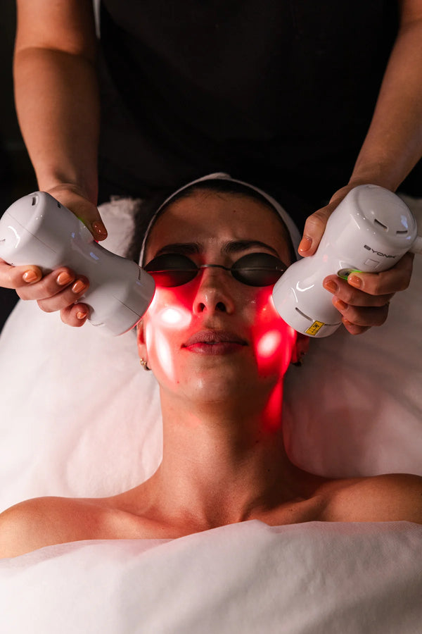 Person receiving a laser treatment on their face with red light therapy.